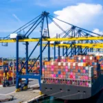 A large cargo ship loaded with colorful shipping containers, The blue sky hints at smooth sailing, ideal for keeping FBA shipping costs efficient and timely.
